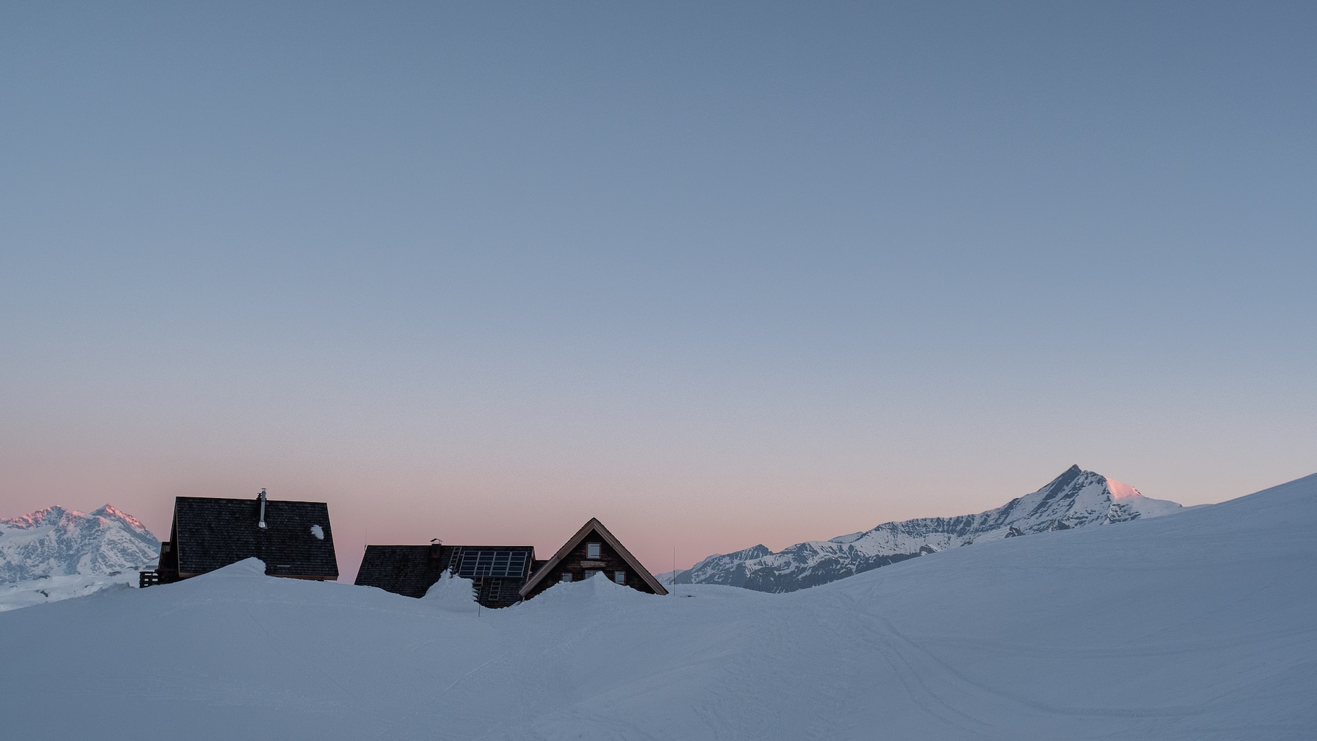 Chalets cerclés de neige au crépuscule